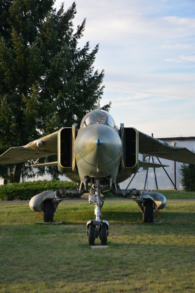 pexels photo 35466899 Front view of a military jet on grass, set against a clear sky.